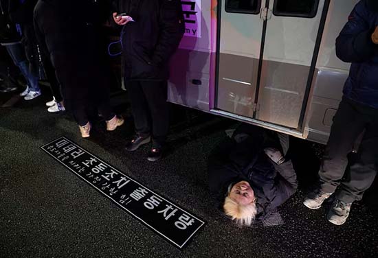 1733293461256066047.jpg 4日一名婦女躺在路上,阻擋運送軍隊的車輛。(路透社).jpg
