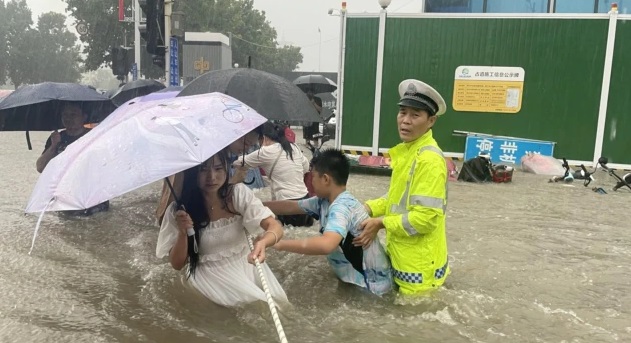 河南省郑州市一名交通警察用一条绳子帮助居民过洪水湍急的街道。 (2021年7月20日).jpg 河南省郑州市一名交通警察用一条绳子帮助居民过洪水湍急的街道。 (2021年7月20日).jpg