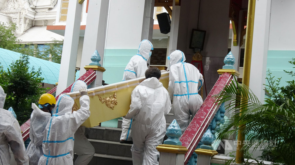 泰國第三波疫情嚴峻,8月中旬以來死亡人數每日新增破200人,寺廟協助火化死者屍體,圖為工作人員和僧侶穿上防護衣搬運棺材到火化爐前。中央社記者呂欣憓曼谷攝.jpg 泰國第三波疫情嚴峻,8月中旬以來死亡人數每日新增破200人,寺廟協助火化死者屍體,圖為工作人員和僧侶穿上防護衣搬運棺材到火化爐前。中央社記者呂欣憓曼谷攝.jpg
