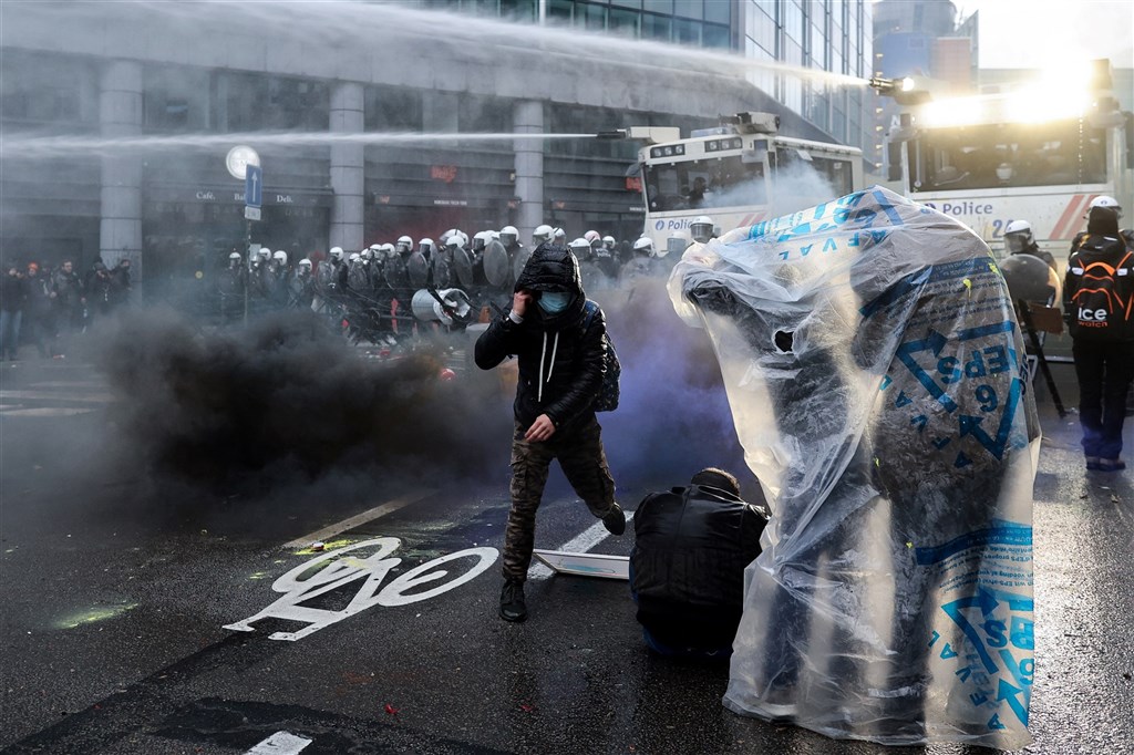 比利時民眾5日上街抗議防疫管制,朝員警扔擲石塊與爆竹,警方發射催淚瓦斯與強力水柱驅散群眾。(法新社).jpg 比利時民眾5日上街抗議防疫管制,朝員警扔擲石塊與爆竹,警方發射催淚瓦斯與強力水柱驅散群眾。(法新社).jpg